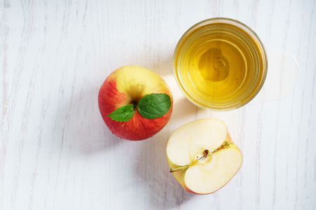 Red apple juice with fresh sliced pieces on white wooden background. top view.の写真素材