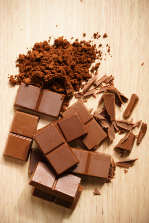chocolate bars and chopped pieces chocolate on wooden backgroundの写真素材