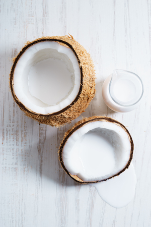 Coconut with half and coconut milk on white backgroundの写真素材