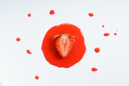 strawberry fruit abstract in red watercolor on white background. freeform shape around sliced object. top view.の写真素材
