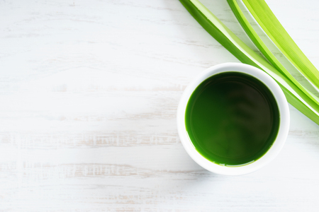 Fresh pandan leaves and pandan juice on white wooden backgroundの写真素材