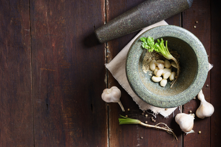 ingredient herbs for Thai cuisine; garlic, pepper and coriander, and stone mortarの写真素材