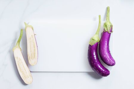 Fresh eggplants with white cutting boardの写真素材