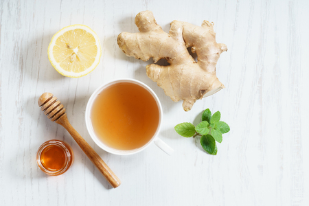 ginger tea in white cup with fresh ginger and lemonの写真素材