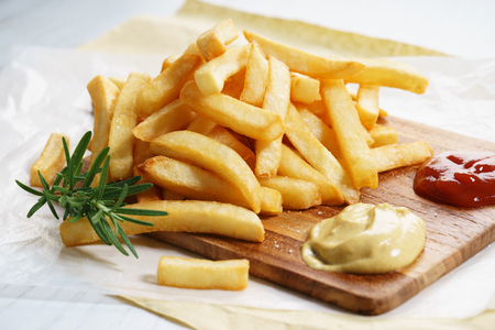 French fries with ketchup and fresh rosemaryの写真素材