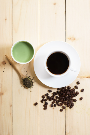 Cup of coffee and green tea late on wooden tableの写真素材