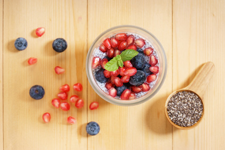 chia seed pudding with fresh blueberries and pomegranate on wooden tableの写真素材
