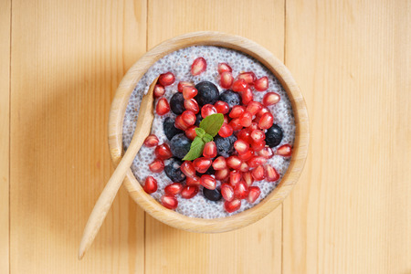 chia seed pudding with fresh blueberries and pomegranate on wooden tableの写真素材