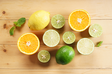lime, lemon and orange, citrus fruits, on wooden tableの写真素材