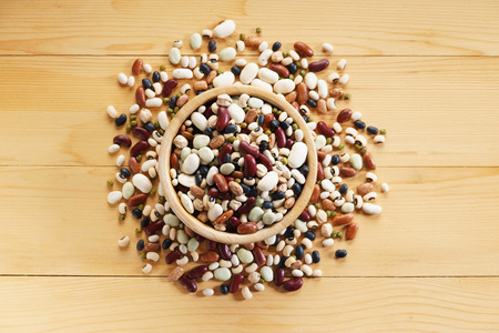 mixed beans in wooden bowl on wooden backgroundの写真素材