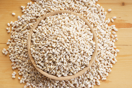 barley rice in wooden bowl on wooden backgroundの写真素材