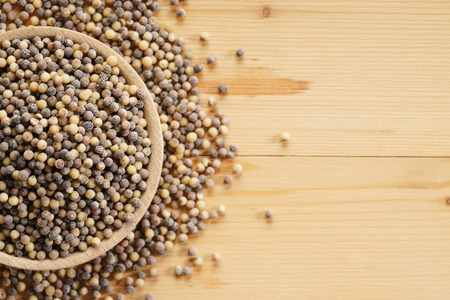 black pepper in wooden bowl on wooden backgroundの写真素材