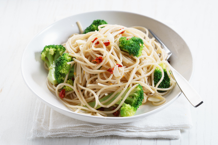 whole wheat spaghetti pasta with stemmed broccoli, chili and lemonの写真素材