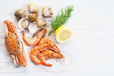 Crustacean seafood with lemon and drill on wooden table