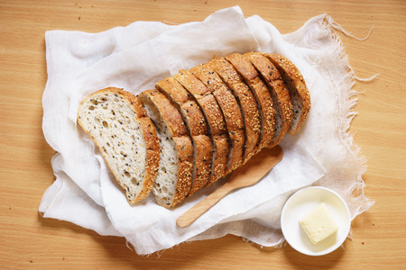 Sliced bread with butter on wooden tableの写真素材