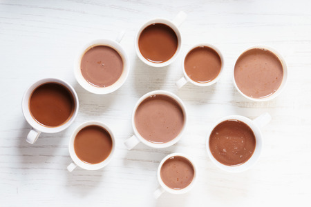 Hot chocolate drinks in white cup on white wooden tableの写真素材