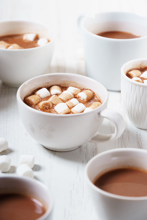 Hot chocolate drinks in white cup on white wooden tableの写真素材