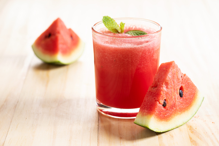 Watermelon sliced and watermelon smoothie on wooden backgroundの写真素材
