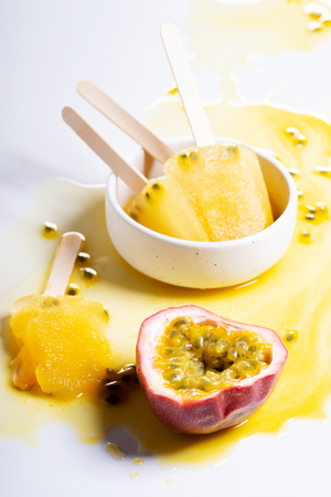 Ice cream from passion fruit juice,  ice lolly melt on white backgroundの写真素材