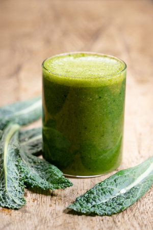 Fresh green smoothie with kale  leaves. Healthy green smoothie  on wooden backgroundの写真素材