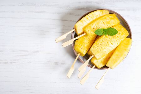 Fresh sliced pineapple in bowl with copy space, top viewの写真素材