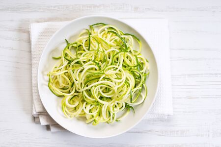 Zucchini noodles in white plate, top viewの写真素材