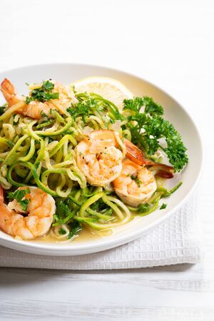 zucchini pasta with shrimps on white plateの写真素材