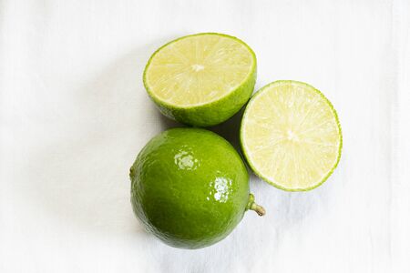Fresh lime, green lemon, as whole and slice on white backgroundの写真素材