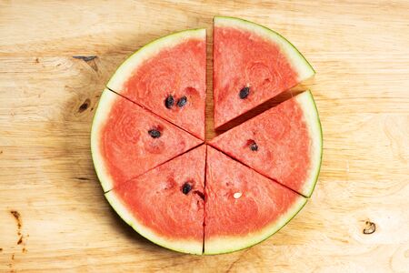 Fresh watermelon slices in a triangle on wooden background, top viewの写真素材