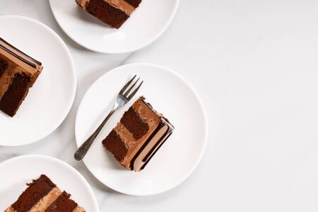 Pieces of layered dark chocolate cake on white plate, top viewの写真素材