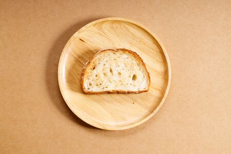 toasted plain whole grain bread on wooden dish, top viewの写真素材
