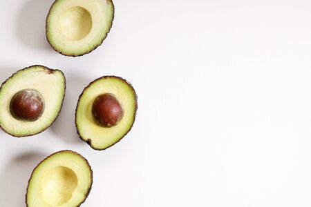 Organic avocado with seed and avocado halves  on white background
