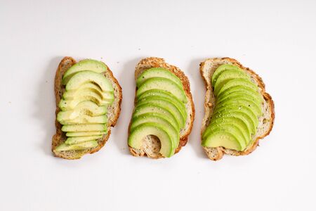 avocado toast with fresh sliced avocado topping on white backgroundの写真素材