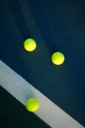 soft focus of tennis balls on blue hard court with sunlightの写真素材