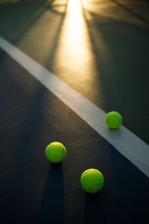 soft focus of tennis balls on blue hard court with sunlightの写真素材