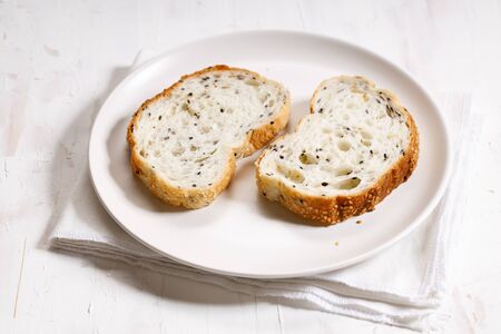 sliced sesame white bread on white plate on white tableの写真素材