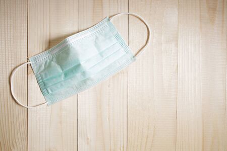 Medical mask for protection against coronavirus on wooden table