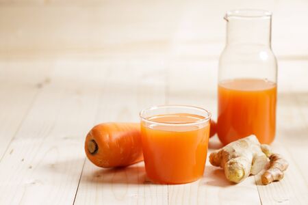 Carrots, ginger, turmeric detox fresh juice on woodenの写真素材