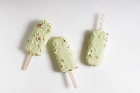 Green mint ice cream coat with white chocolate and almond on whiteの写真素材