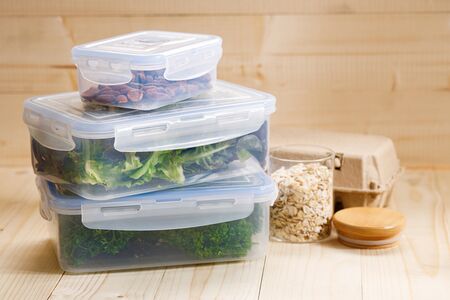 boxes with raw vegetables for stocking up, home food storage in plastic containers, on wooden...