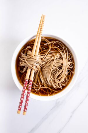 soba noodles, zaru soba, in white bowl with bamboo chopsticksの写真素材