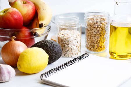 Culinary, cooking and healthy food concept. Food ingredients on white table with notebook for checklistの写真素材