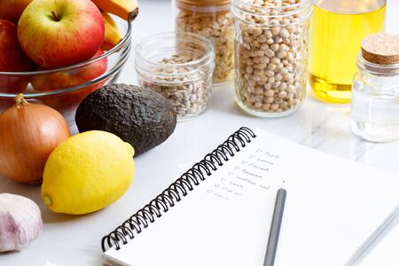 Culinary, cooking and healthy food concept. Food ingredients on white table with notebook for checklistの写真素材