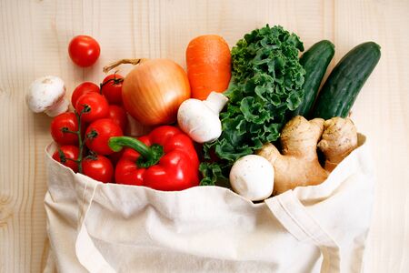 Vegetables in cloth bag on light wooden background. food bag and eco-friendly concept. Healthy food background.の写真素材