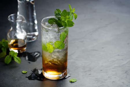 mojito cocktail, cold drink with ice cubes and fresh mint leaves on rustic dark table.の写真素材