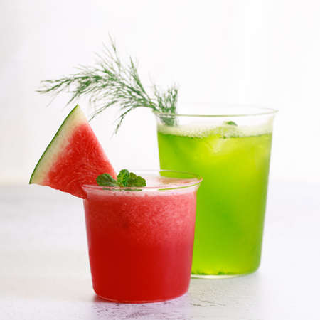 Cold refreshing drinks with watermelon and green cocktail in a glasses on white marble background.の写真素材