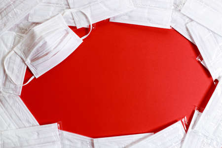 medical masks for protection against coronavirus on red color background. Top view.の写真素材