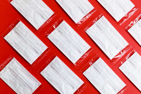 medical masks for protection against coronavirus on red color background. Top view.の写真素材