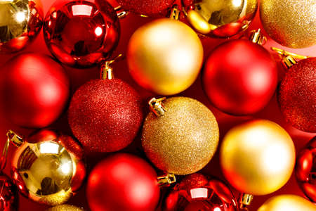Chirstmas holiday festive baubles with red and golden color closeup on red backgroundの写真素材