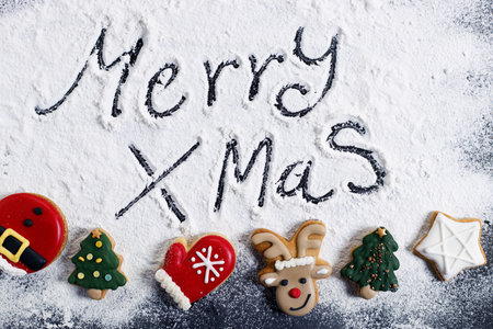 Merry Christmas, handwriting, on flour background with Christmas cookies. top view with copy space.の写真素材